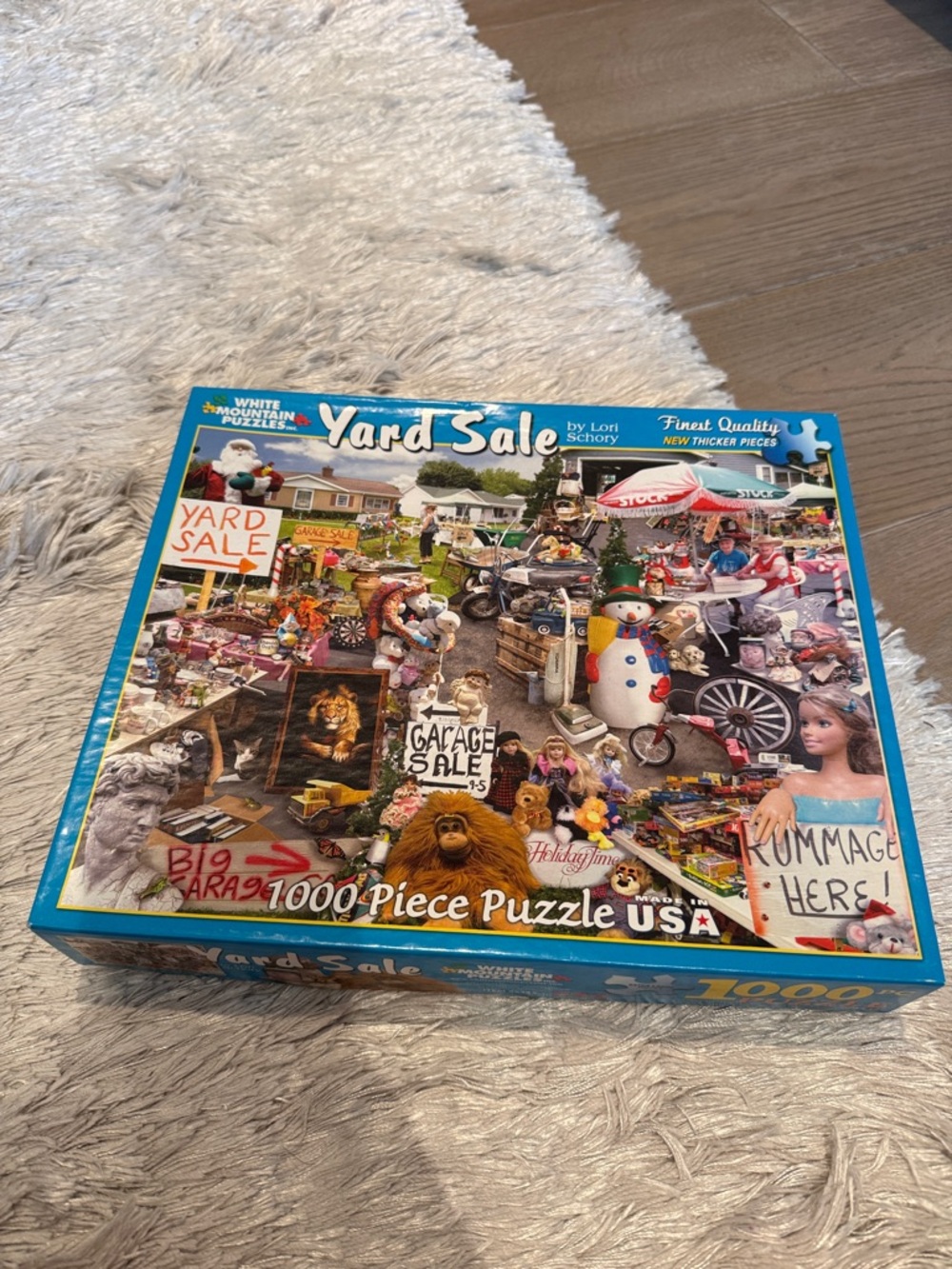White Mountain Yard Sale Puzzle with Blue Border and Multicolored Scene